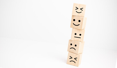 Customer service evaluation and satisfaction survey concepts. Happy face smile face symbol on wooden cube, copy space