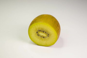 Half of the kiwi is on a white table