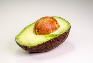 half an avocado lies on a white table