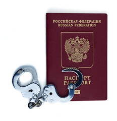 Passport of the Russian Federation with handcuffs isolated on a white background. Close-up, top view.