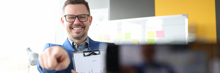 Young man showing mobile phone screen with finger