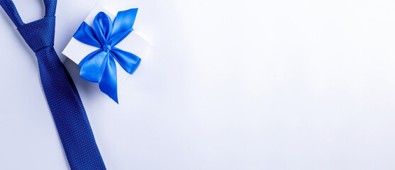 Gift dad. Blue bowtie or tie, white box with bow ribbon on light background. Happy loving family and Fathers Day concept.