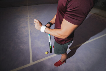
a young paddle player putting on a wristband.