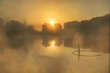 Misty sunrise over ponds in oranges and yellows