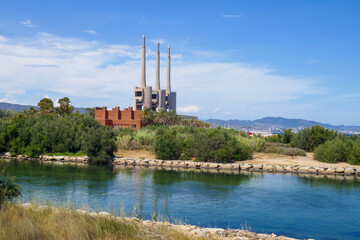 San Adrian, Fecsa Central Termica thermal power station in Badalona, Barcelona, Spain. Abandoned boiler room with three chimneys surrounded by nature