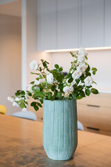 White roses decorating modern office. Modern office interior design detail. Biophilic design concept.