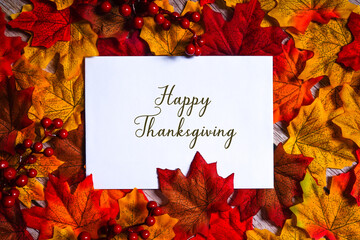 Happy thanksgiving card surrounded by colorful maple leaves and red berries. Autumn & fall holiday...