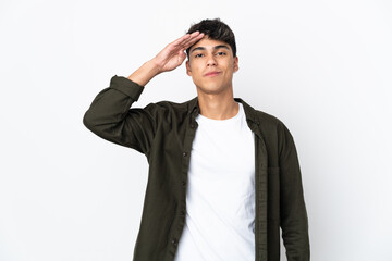 Young man over isolated white background saluting with hand with happy expression