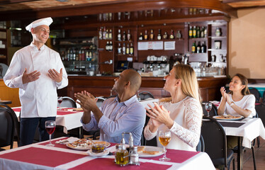 Restaurant guests applaud and thank the restaurant chef
