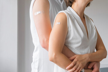 Unrecognized Vaccinated Male and Female Showing Arm With Medical Patch Plaster After Covid-19 Vaccine Injection. Coronavirus Vaccination Advertisement Campaign. Vaccine Done. Young vaccinated family