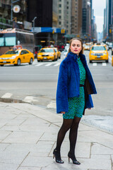 Dressing in a blue faux fur coat,  patterned dress, black leggings and leather shoes, a pretty...