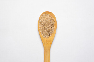 Sesame seeds in a  spoon on  white background