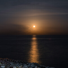 Fototapeta premium Moon coming up over the sea