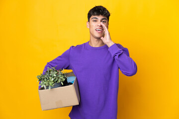 Man making a move while picking up a box full of things shouting with mouth wide open