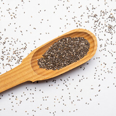 Chia seeds in wooden spoon on white backgrond