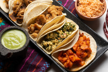 Different types of tacos also called guisados on a white background. Mexican food