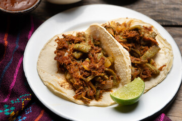 Mexican food. Chilorio and nopales tacos on wooden background