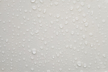 Water droplets on shiny white metallic surface