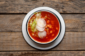 Mexican food. Red pozole with chicken on wooden background