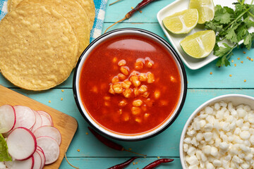 Mexican food. Red pozole with chicken on turquoise background