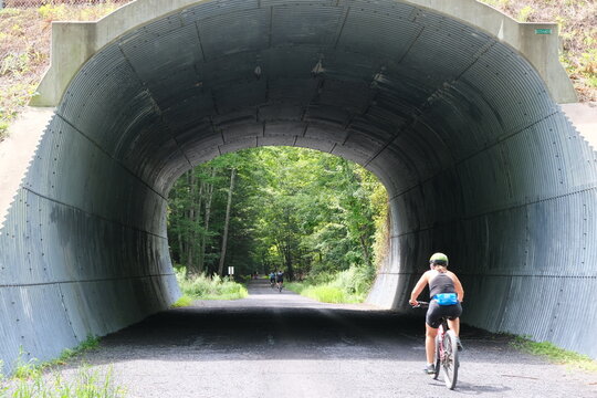 A cyclist on the Ashokan Rail Trail in West Hurley, New York, heads through a tunnel along the 12 mile path.