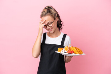 Restaurant waiter Russian girl holding waffles isolated on pink background laughing