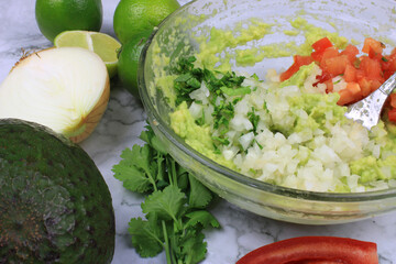 Ingredients to make guacamoles in a bowl before mixing 