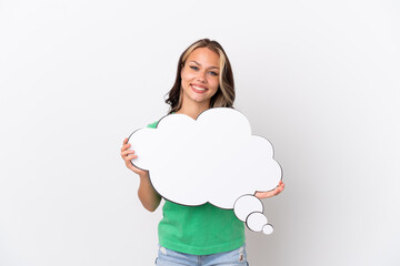 Teenager Russian girl isolated on blue background holding a thinking speech bubble