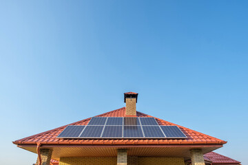 Solar panels on the roof of a private house on blue sky background © Serhii