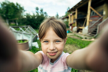 A little girl takes a selfie in the village.