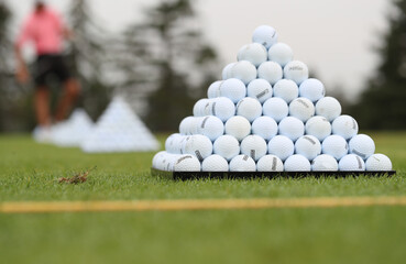 Golf balls are stacked up as players warm up prior to playing in a tournament.