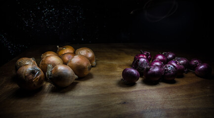 Obraz premium Vegetable concept. Onions in dark on wooden table. Selective focus