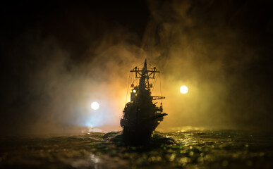 Silhouettes of a crowd standing at blurred military war ship on foggy background. Selective focus. © zef art
