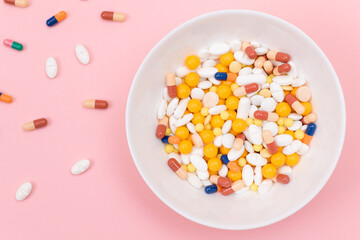 Fototapeta na wymiar Global Pharmaceutical Industry and Medicinal Products - Colored Pills and Capsules in White Dish on Pink Background
