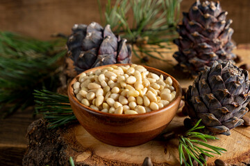 Pine nuts and cedar cones on rustic wooden background