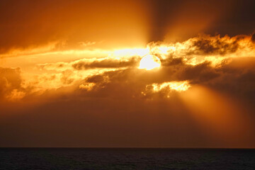 The sunlight appeared and disappeared from time to time between the clouds. The haze is very spectacular. The sunset seen from the boat. North Pacific Ocean, June, 2019.