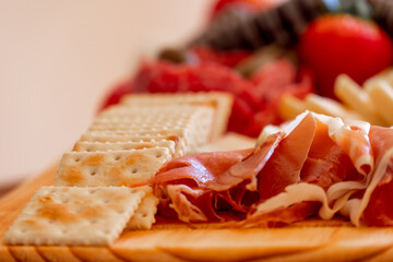 Close up of a small cheese table with serrano ham and cookies