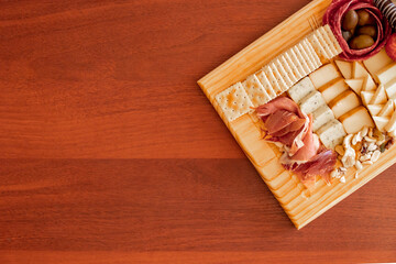 High angle view of a small cheese table with serrano ham and cookies