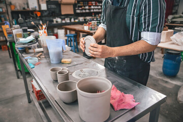 young adult potter preparing some pieces of clay to put in the kiln