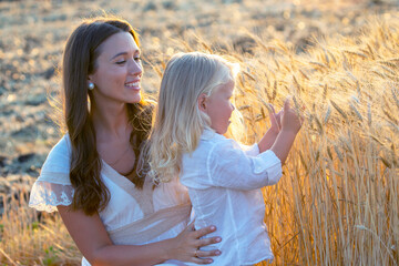 happy woman with her beautiful long-haired son in a wheat field. love and motherhood