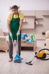 Young male contractor wearing prickly wreath on head cleaning th