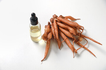 Fingerroot or Boesenbergia rotunda rhizome with bottle of extract on white background.