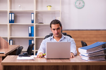 Fototapeta na wymiar Young male employee working in the office