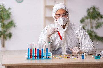 Young male chemist working at the lab during pandemic
