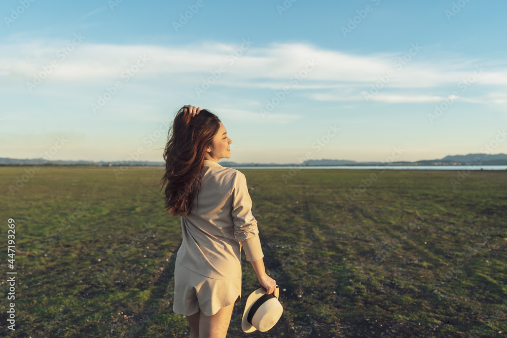 Wall mural cheerful woman walk across the field with sunlight