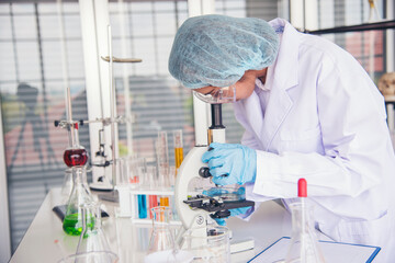 Woman scientist in lab look at science microscope medical test and research biology chemistry....