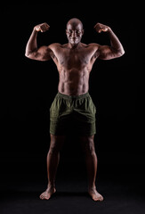 Obraz na płótnie Canvas African American muscular man smiling flexing arm muscles on a black background