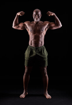 African American muscular man smiling flexing arm muscles on a black background