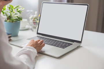 Fototapeta premium Woman using laptop at office desk, blank copy space screen advertising text message. home office concept.