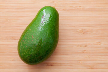 Fresh avocado on wooden background. Organic avocado healthy food concept.. Avocado on Bamboo cutting board.The avocado is popular in vegetarian cuisine and weight control.